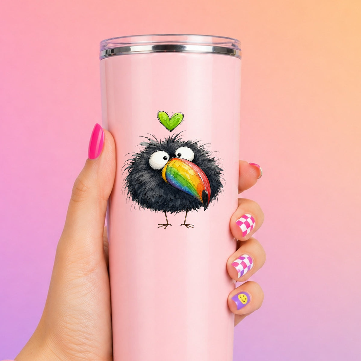 Funny Toucan Rainbow Beak UV DTF sticker applied to a tall pink tumbler on a pink and orange background