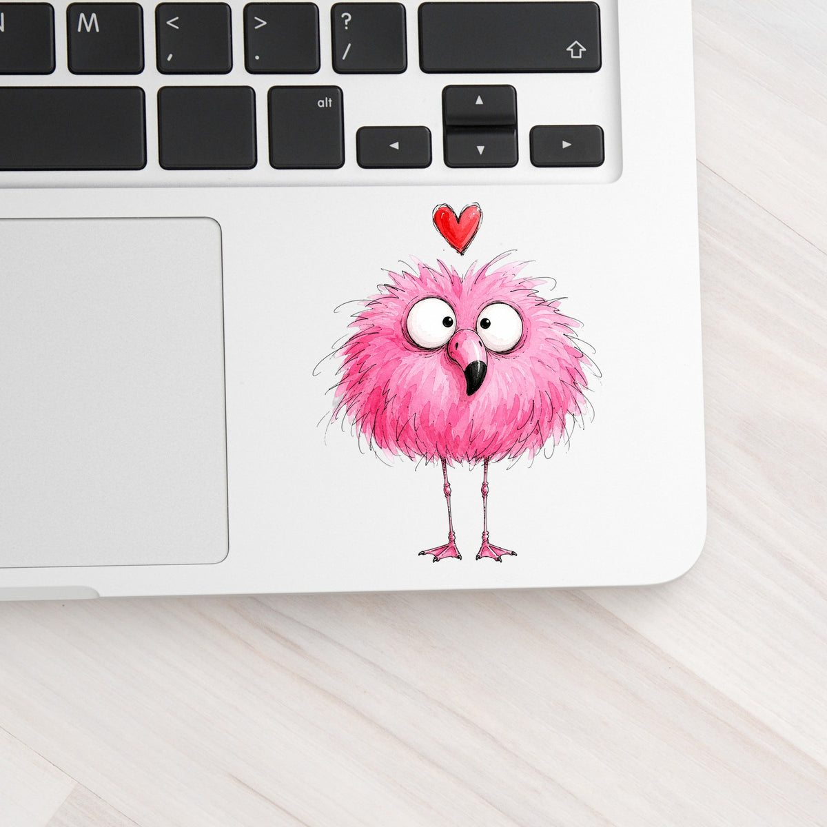 Fluffy Pink Flamingo UV DTF sticker applied to a silver laptop beside the keyboard