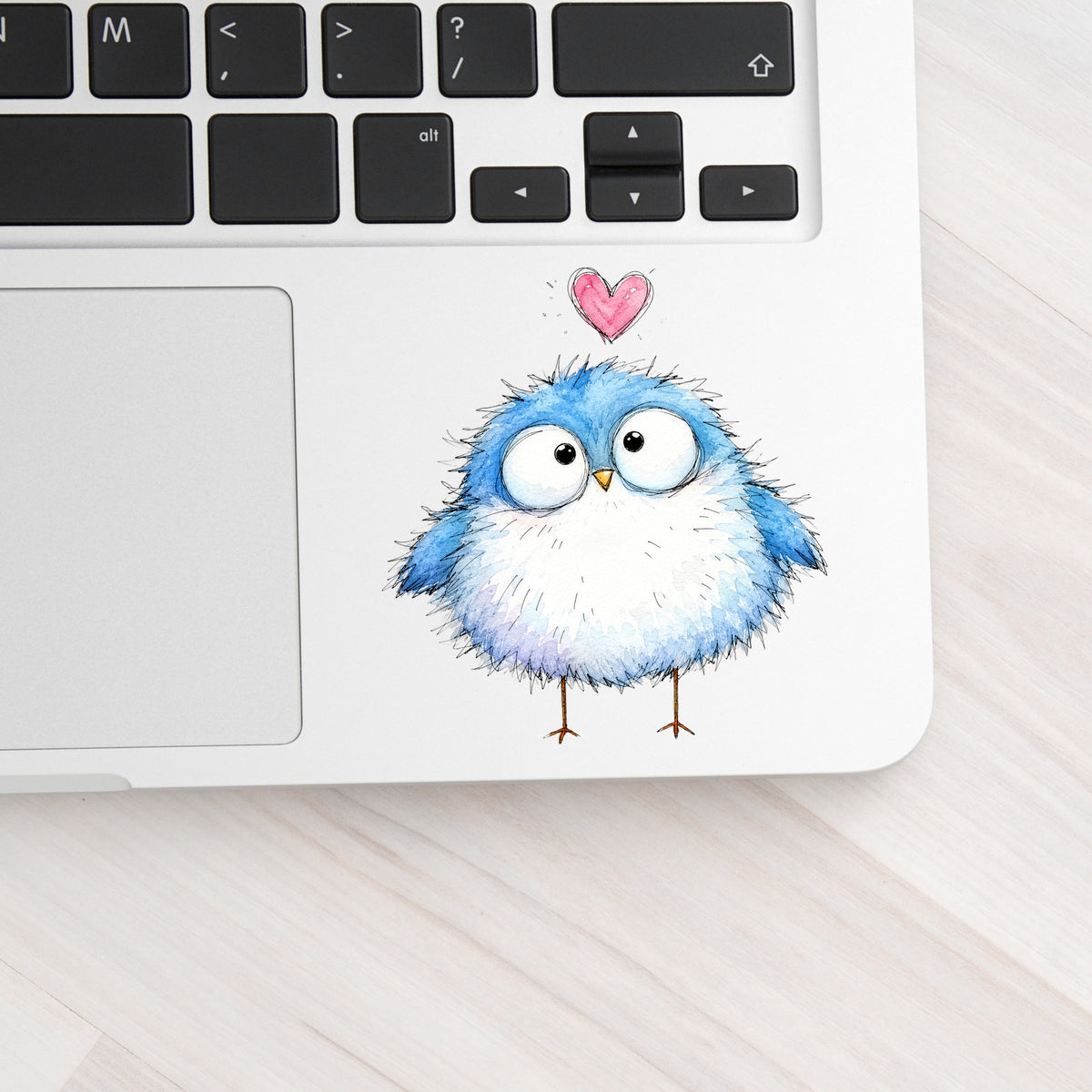 Fluffy Bluebird UV DTF sticker applied to a silver laptop beside the keyboard