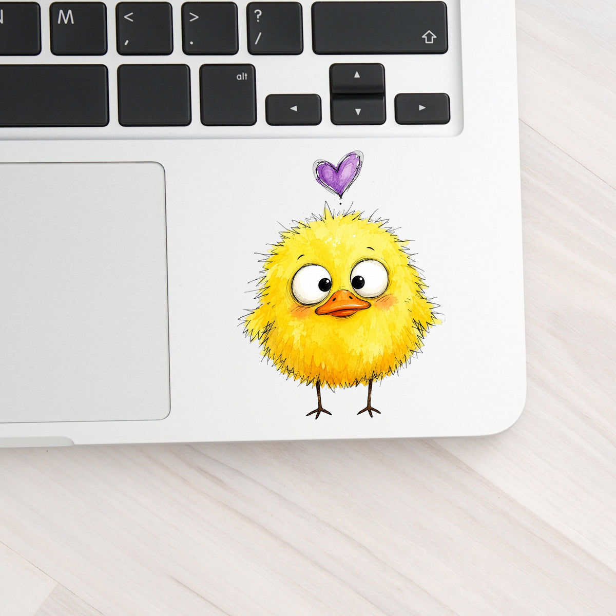Funny Yellow Baby Duck UV DTF sticker applied to a silver laptop beside the keyboard