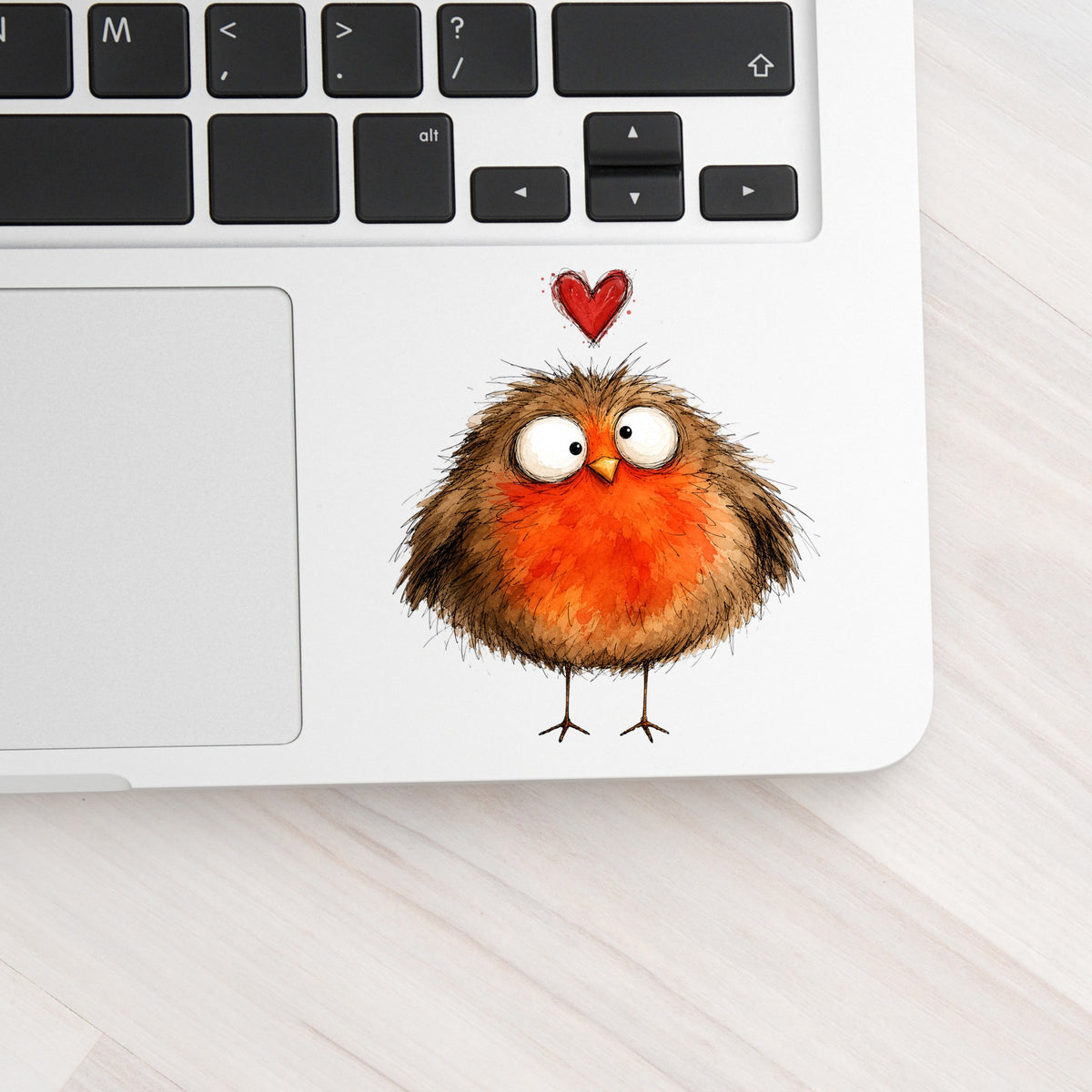 Round Robin Bird UV DTF sticker applied to a silver laptop beside the keyboard