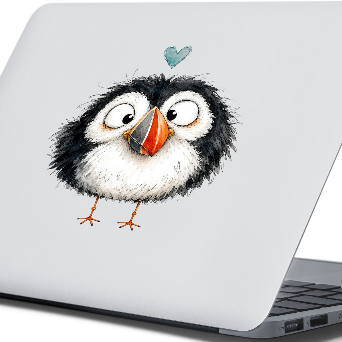 Cartoon Puffin UV DTF sticker applied to the lid of a silver laptop