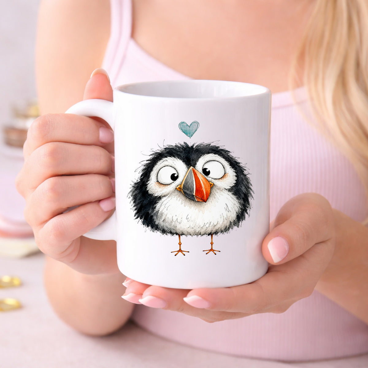 Cartoon Puffin UV DTF sticker applied to a white coffee mug held in both hands