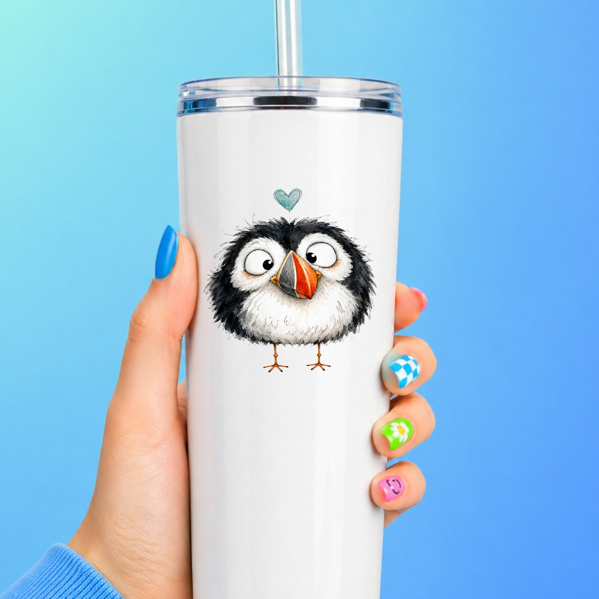 Cartoon Puffin UV DTF sticker applied to a white straw tumbler on a blue background