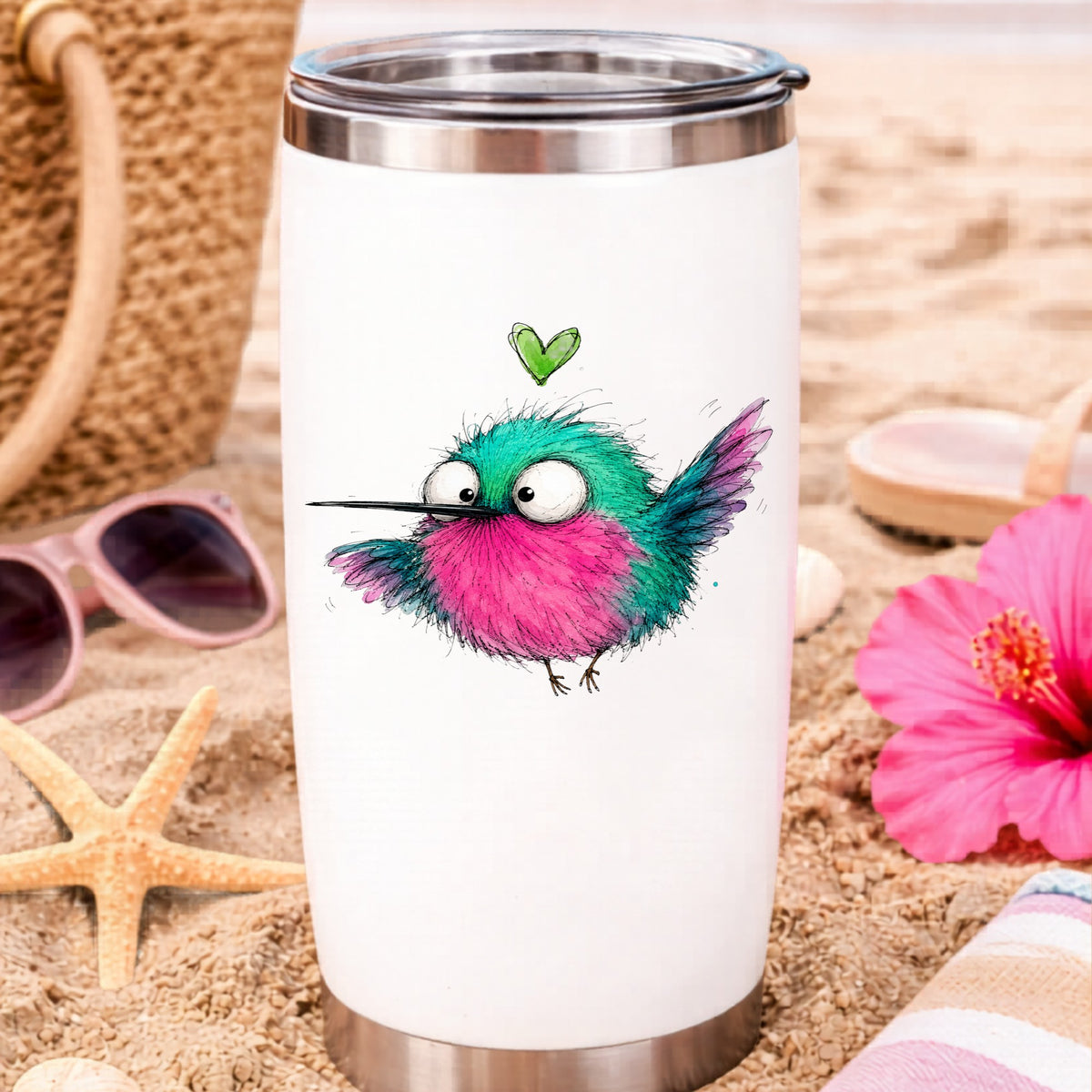 Flying Cartoon Hummingbird UV DTF sticker applied to a white travel tumbler on beach sand