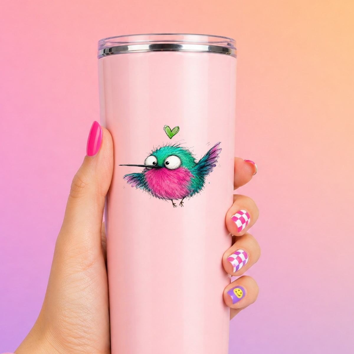 Flying Cartoon Hummingbird UV DTF sticker applied to a tall pink tumbler on a pink and orange background