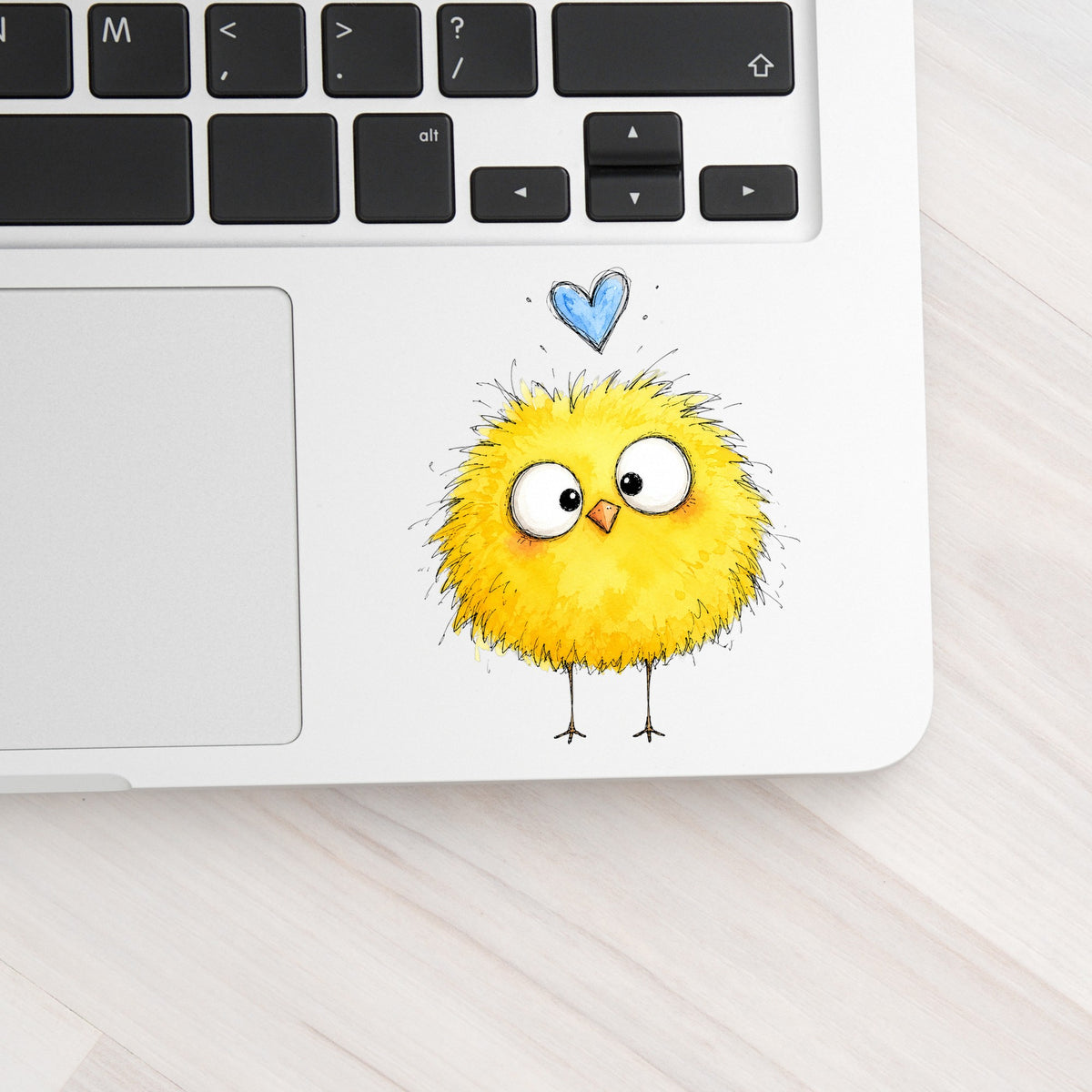 Fluffy Yellow Chick UV DTF sticker applied to a silver laptop beside the keyboard