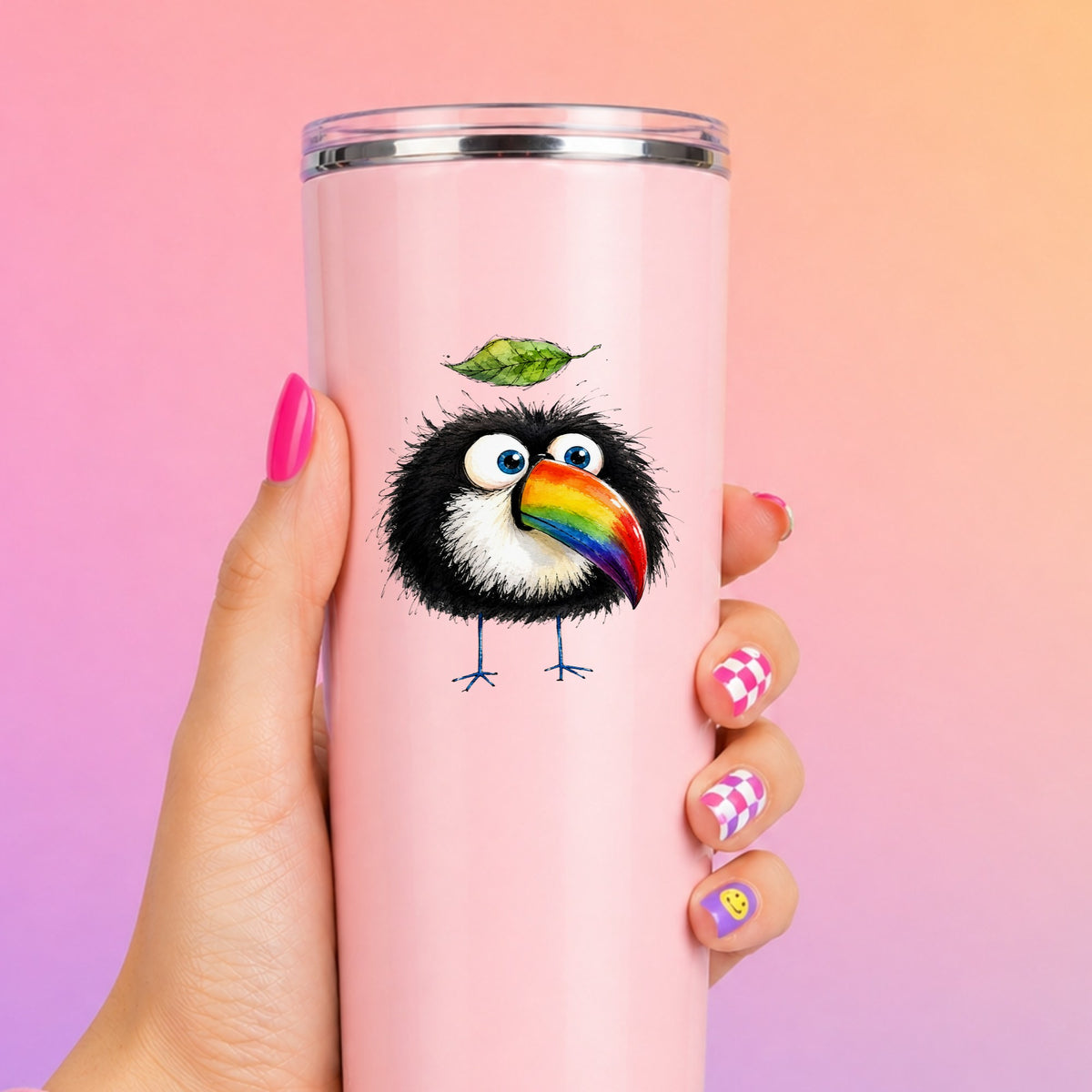 Toucan With Leaf UV DTF sticker applied to a tall pink tumbler on a pink and orange background
