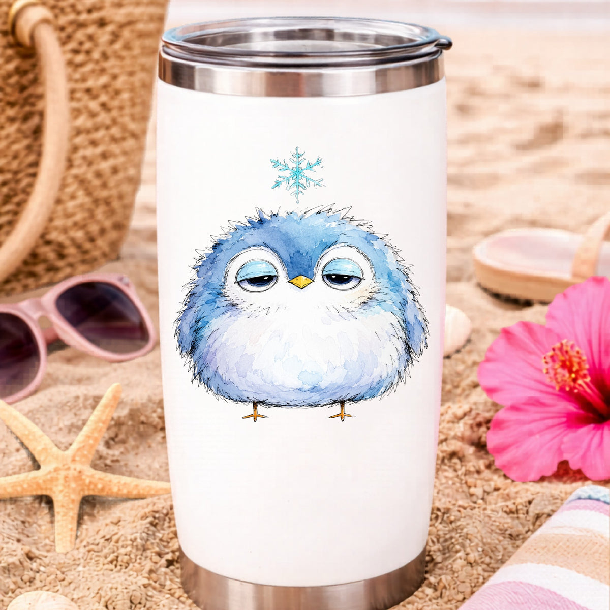 Sleepy Blue Bird Snowflake UV DTF sticker applied to a white travel tumbler on beach sand