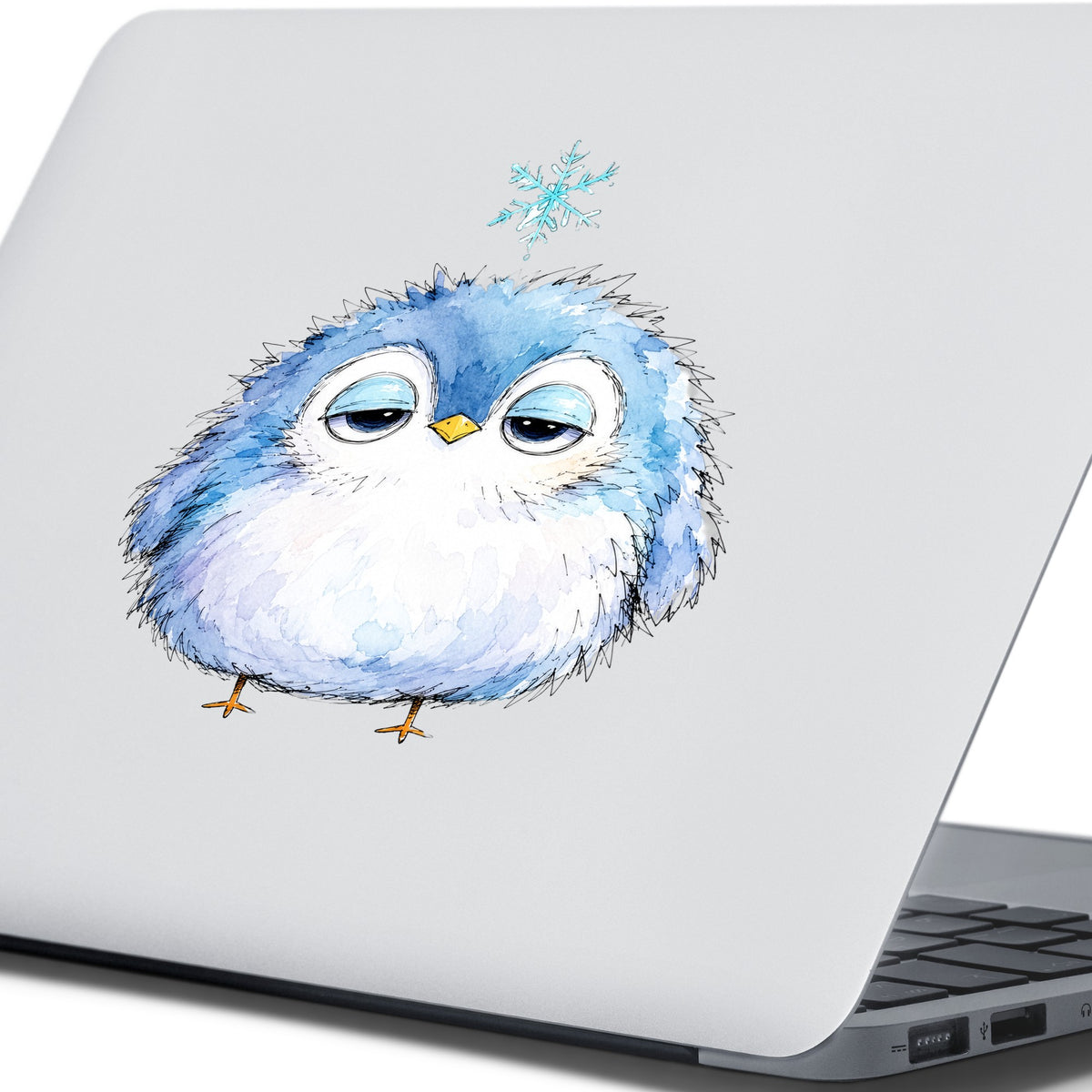 Sleepy Blue Bird Snowflake UV DTF sticker applied to the lid of a silver laptop