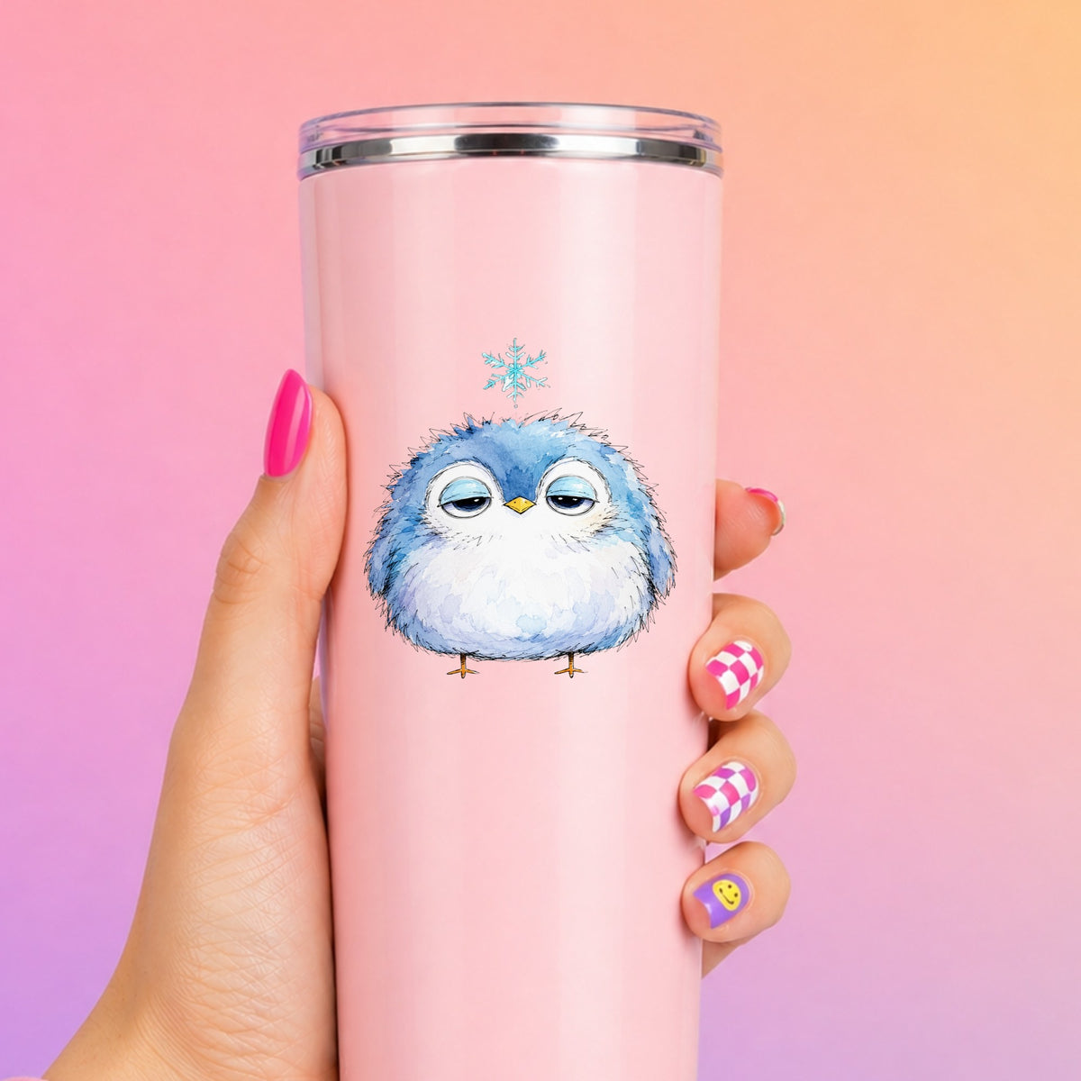 Sleepy Blue Bird Snowflake UV DTF sticker applied to a tall pink tumbler on a pink and orange background
