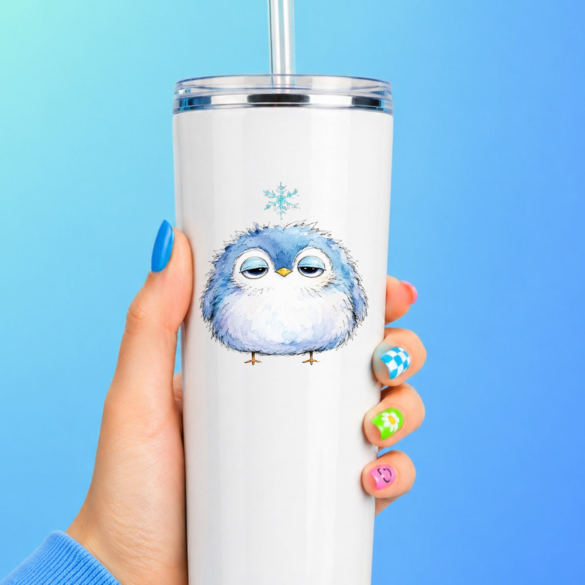 Sleepy Blue Bird Snowflake UV DTF sticker applied to a white straw tumbler on a blue background
