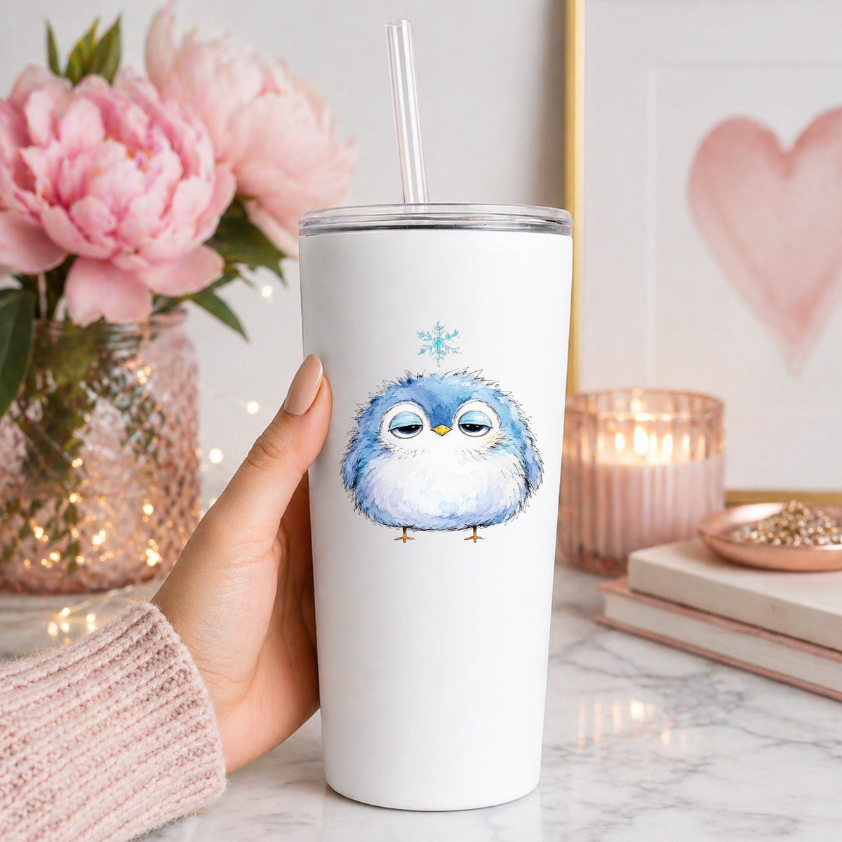 Sleepy Blue Bird Snowflake UV DTF sticker applied to a white straw tumbler beside pink peonies