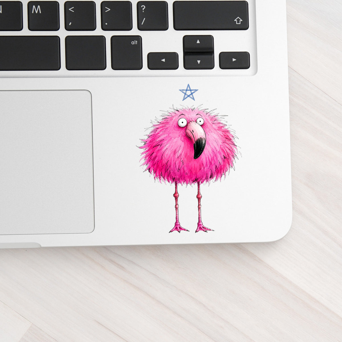 Pink Flamingo With Star UV DTF sticker applied to a silver laptop beside the keyboard