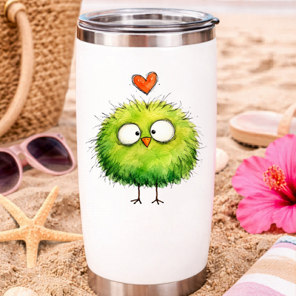Fluffy Green Bird UV DTF sticker applied to a white travel tumbler on beach sand