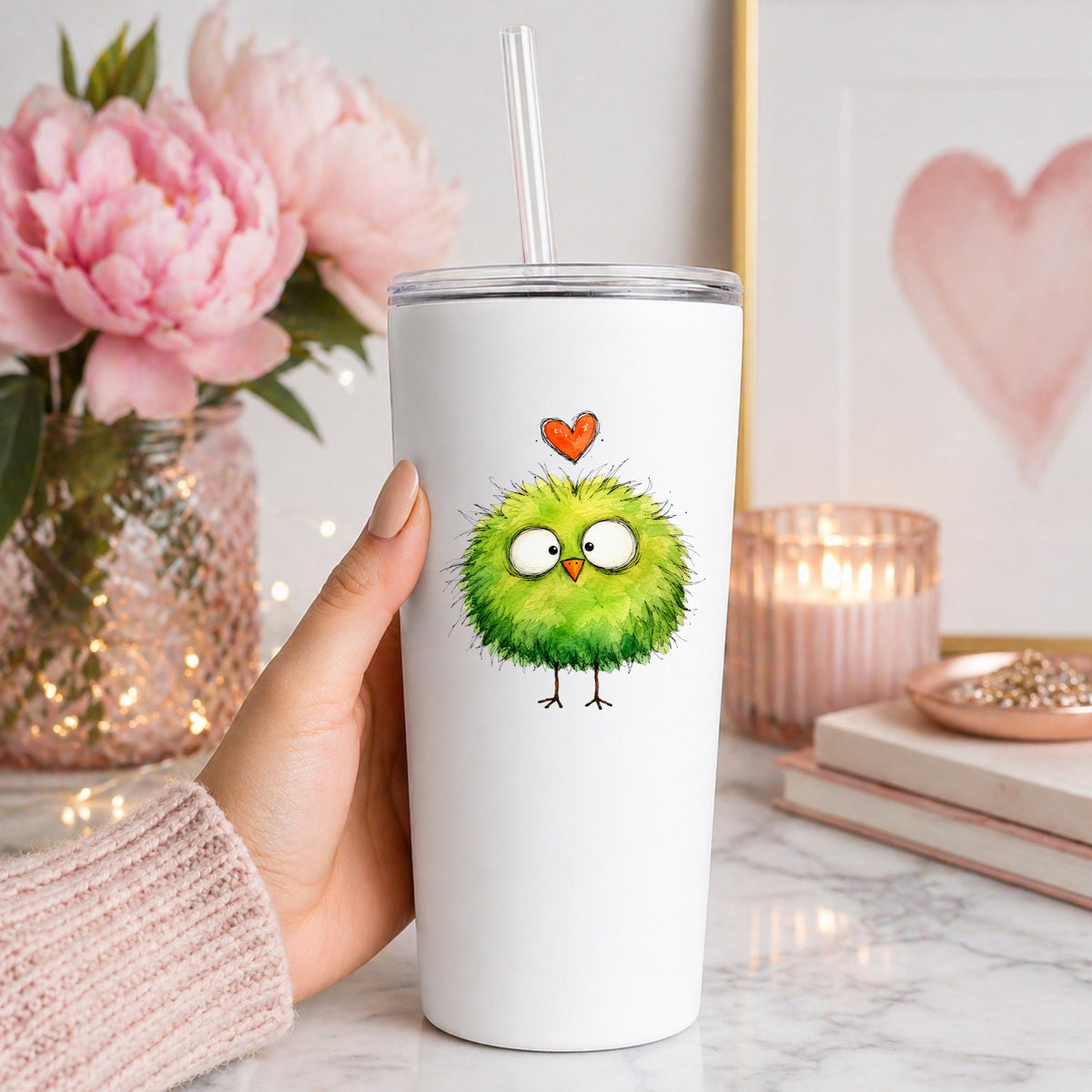 Fluffy Green Bird UV DTF sticker applied to a white straw tumbler beside pink peonies