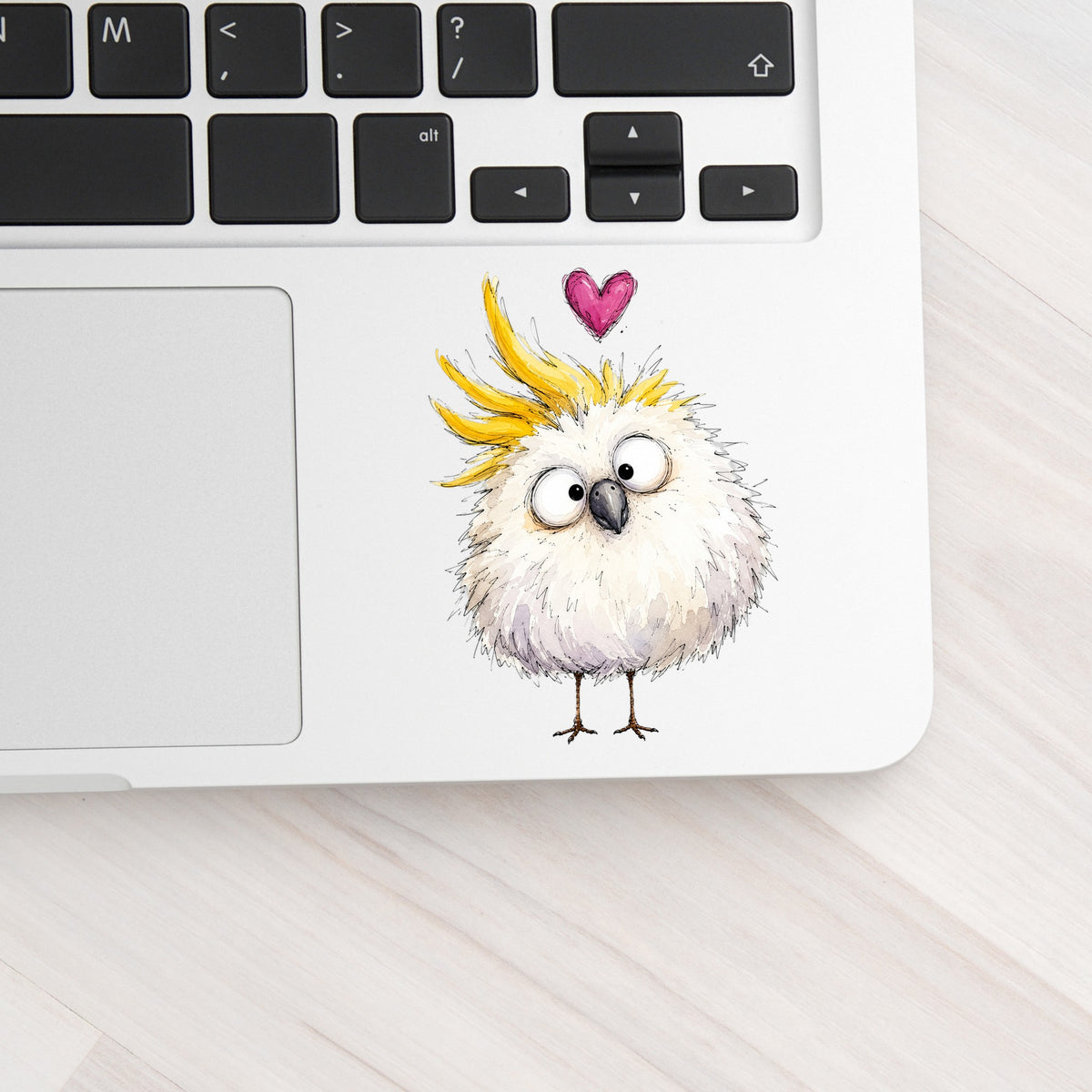 Funny White Cockatoo UV DTF sticker applied to a silver laptop beside the keyboard