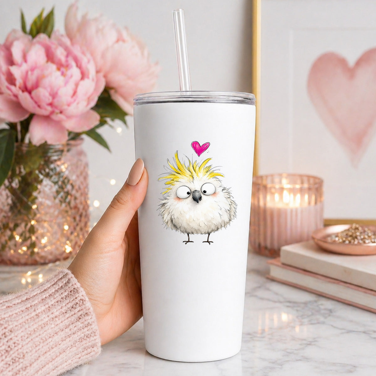 Cartoon Cockatoo Parrot UV DTF sticker applied to a white straw tumbler beside pink peonies