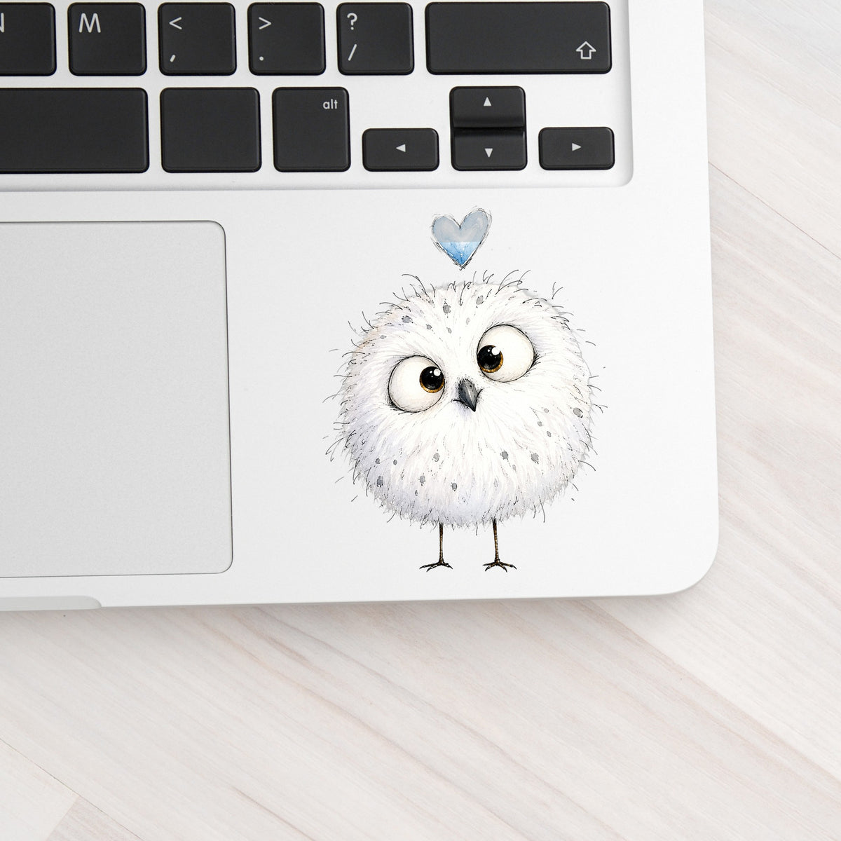 Round White Owl UV DTF sticker applied to a silver laptop beside the keyboard