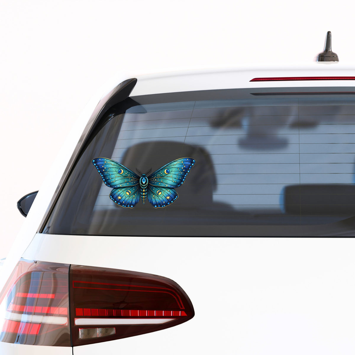 Teal Celestial Moth UV DTF sticker applied to the rear window of a white car