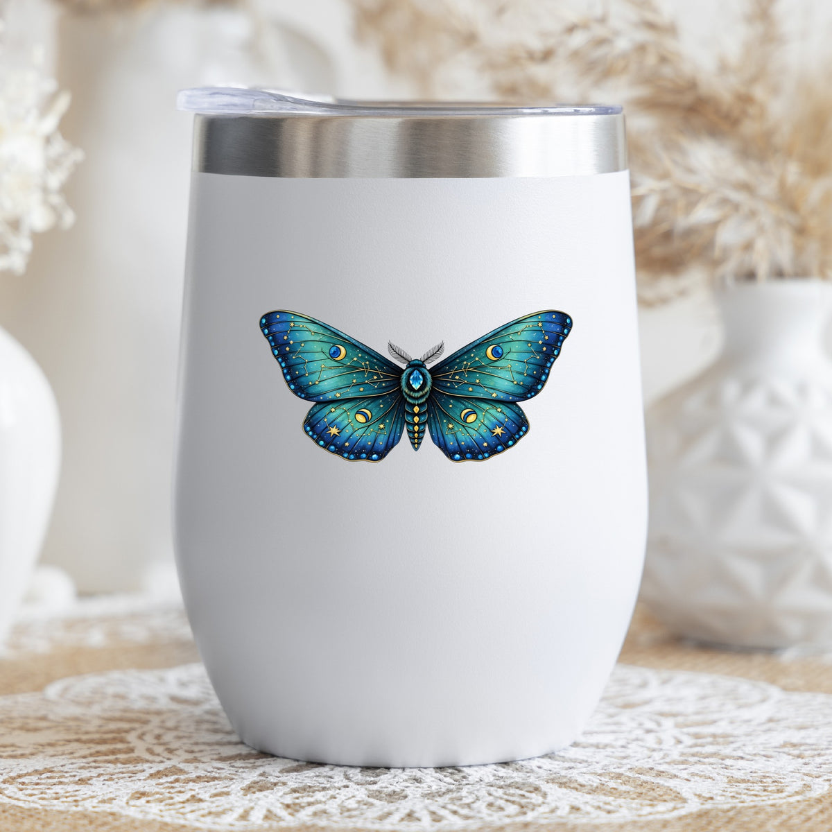 Teal Celestial Moth UV DTF sticker applied to a white stemless tumbler with a lid
