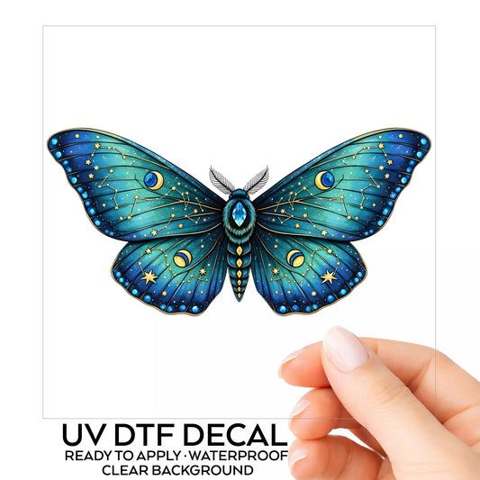 Teal Celestial Moth UV DTF sticker on its backing card, held in hand