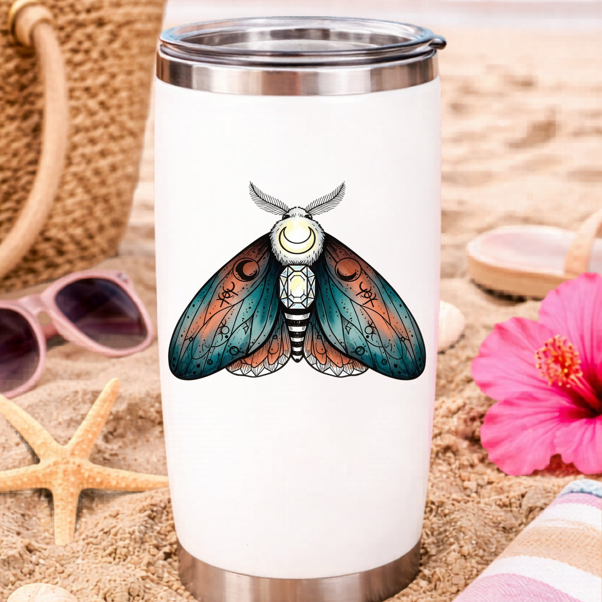 Coral Teal Crescent Moon Moth UV DTF sticker applied to a white travel tumbler on beach sand