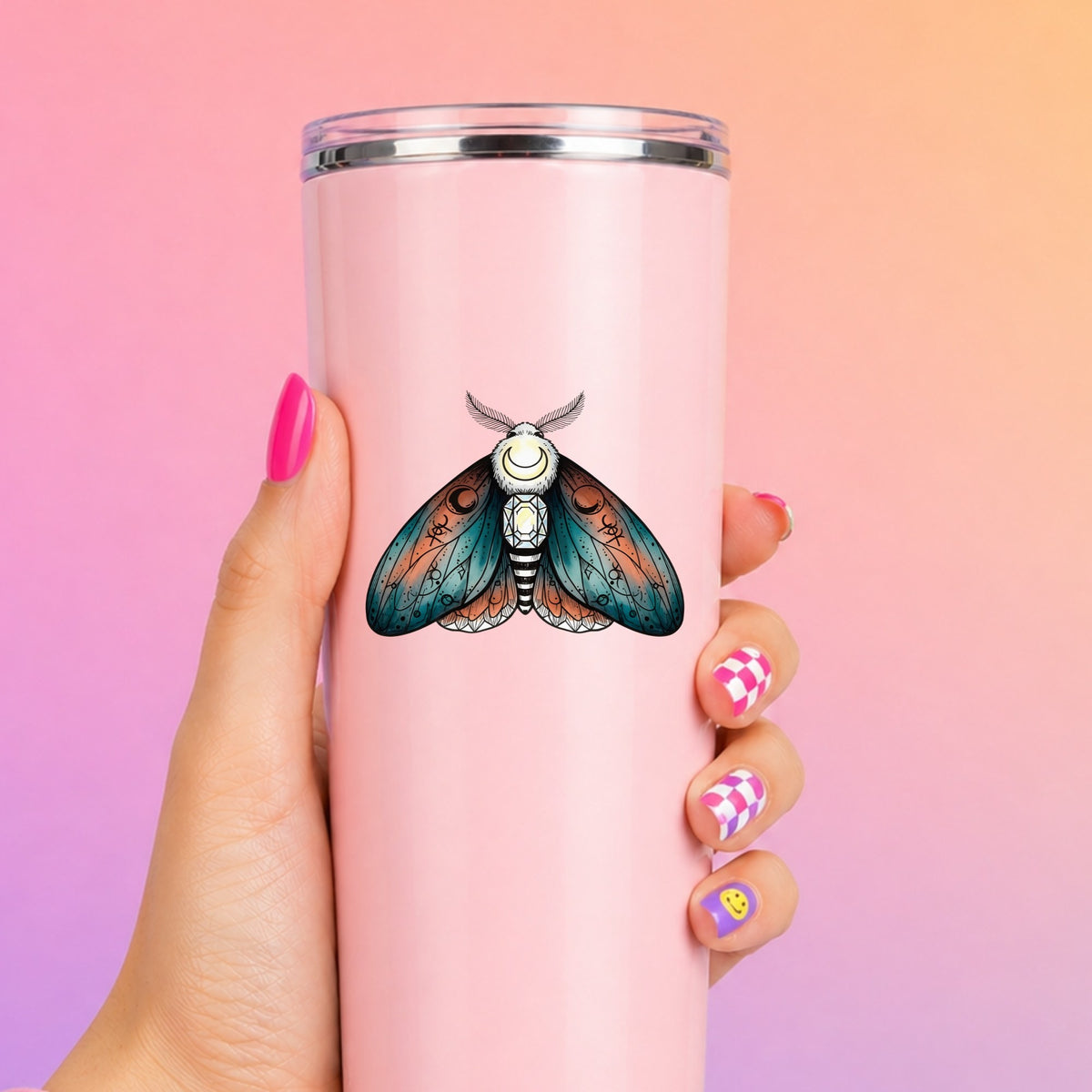 Coral Teal Crescent Moon Moth UV DTF sticker applied to a tall pink tumbler on a pink and orange background