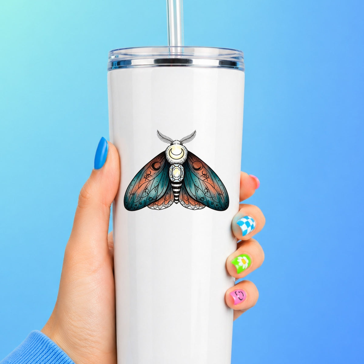 Coral Teal Crescent Moon Moth UV DTF sticker applied to a white straw tumbler on a blue background