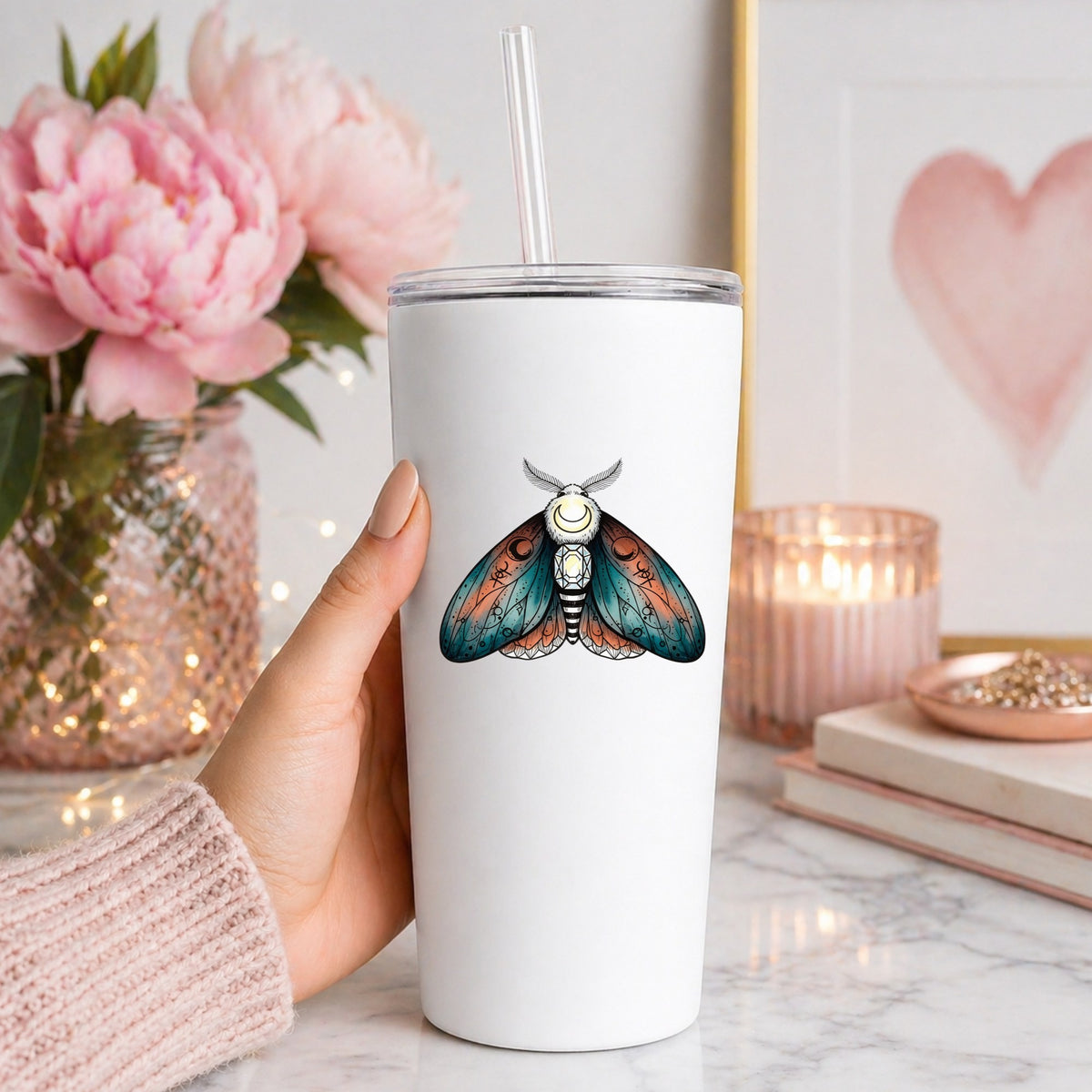 Coral Teal Crescent Moon Moth UV DTF sticker applied to a white straw tumbler beside pink peonies