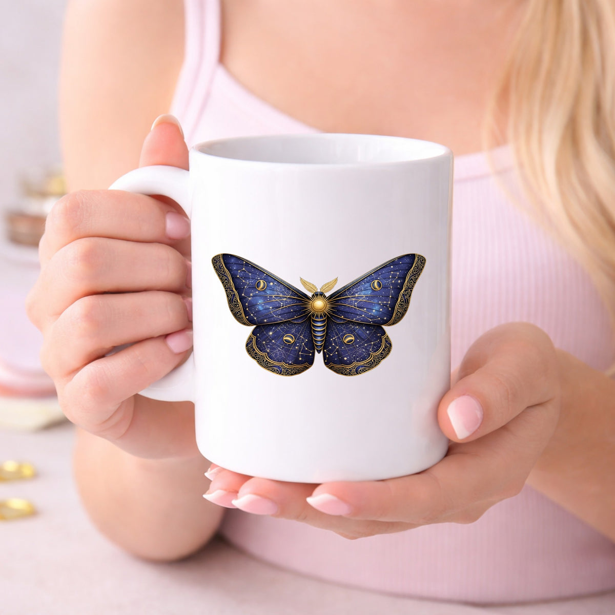Navy Constellation Moth UV DTF sticker applied to a white coffee mug held in both hands