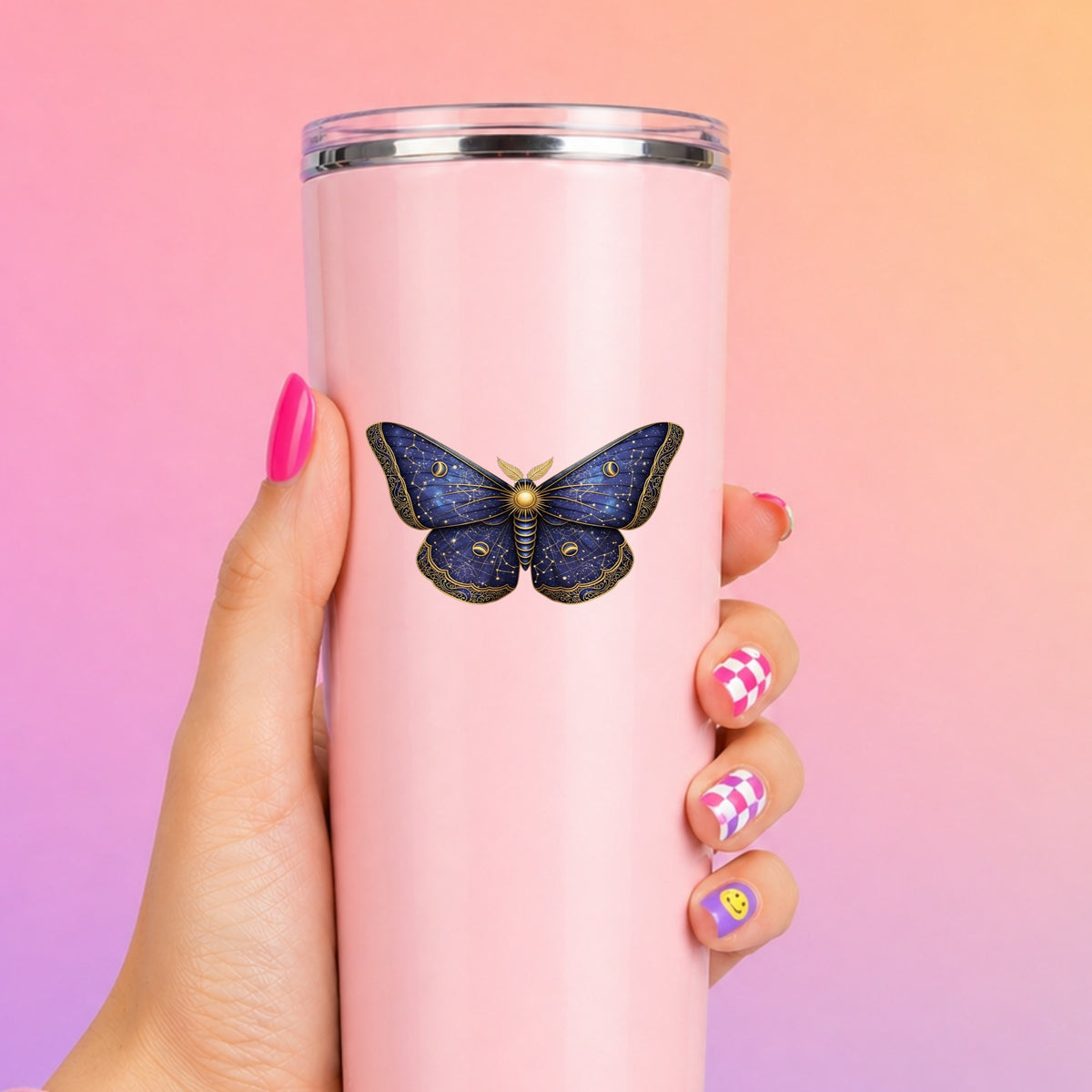 Navy Constellation Moth UV DTF sticker applied to a tall pink tumbler on a pink and orange background