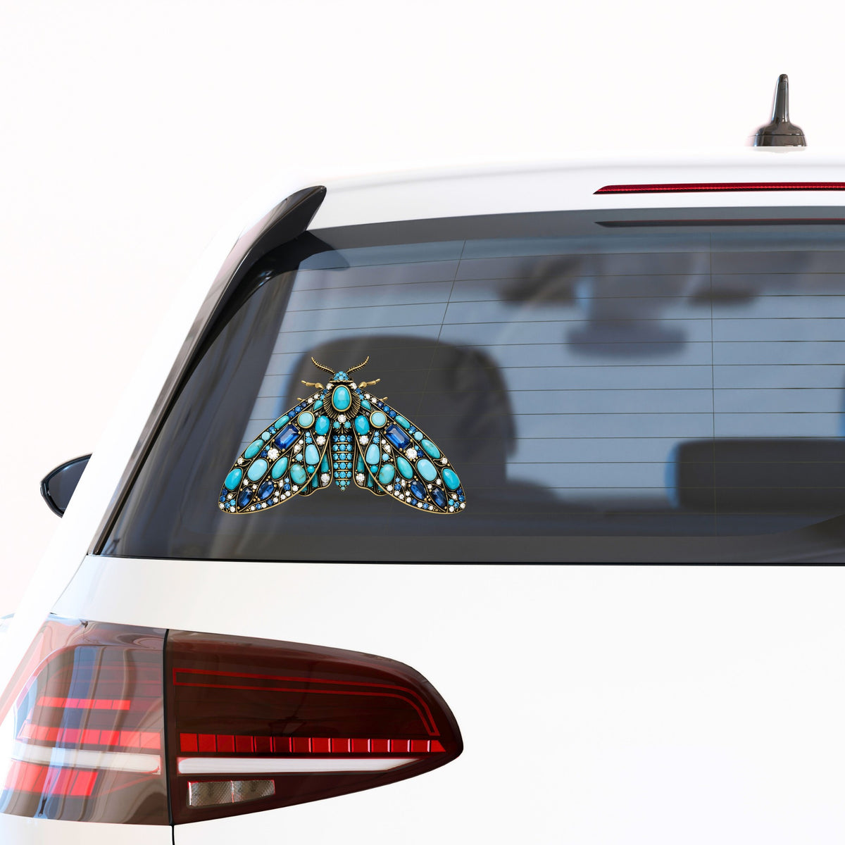 Turquoise Jeweled Moth UV DTF sticker applied to the rear window of a white car