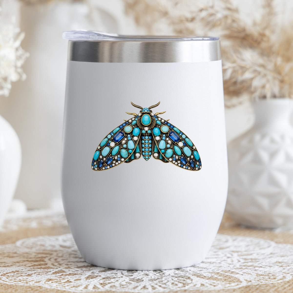 Turquoise Jeweled Moth UV DTF sticker applied to a white stemless tumbler with a lid