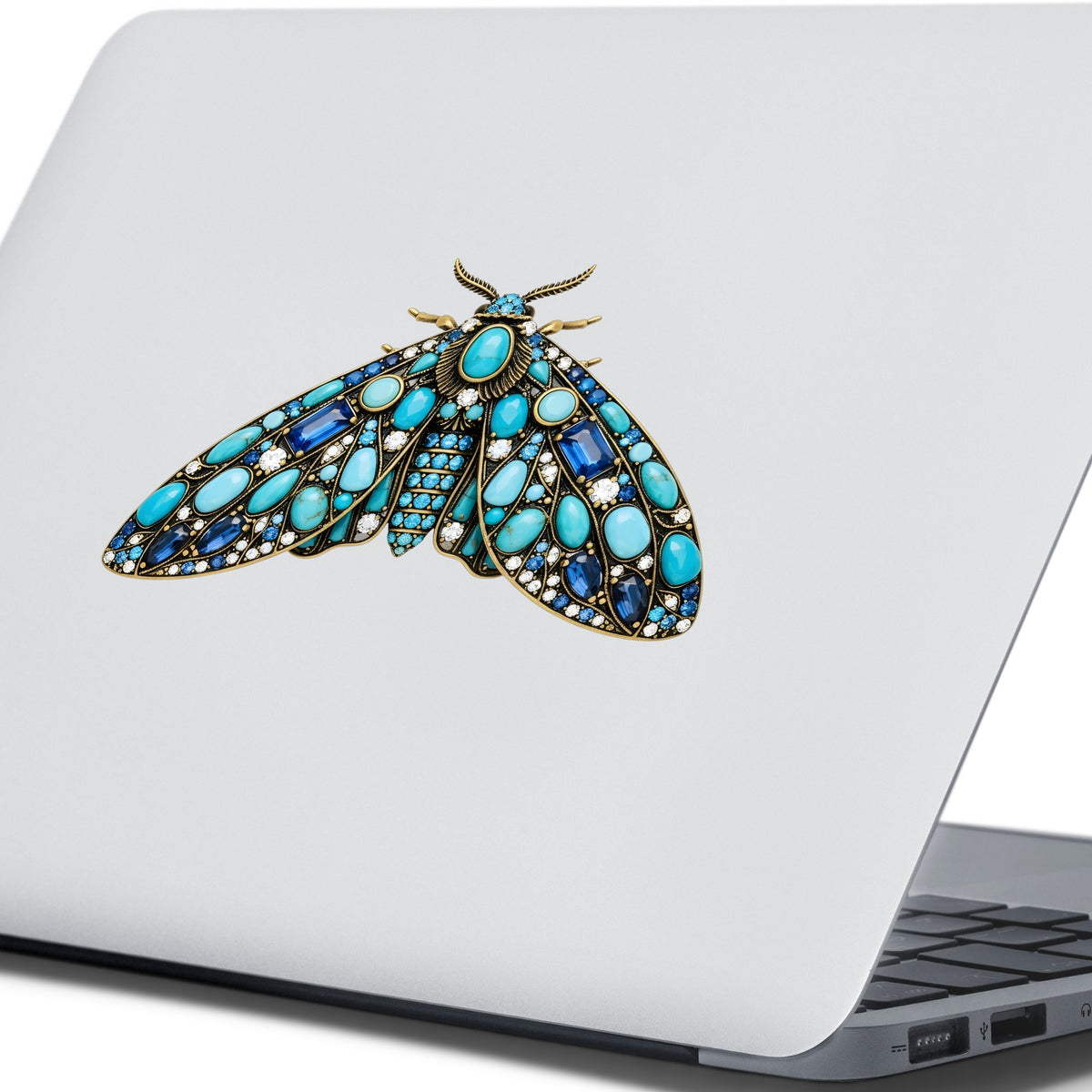 Turquoise Jeweled Moth UV DTF sticker applied to the lid of a silver laptop