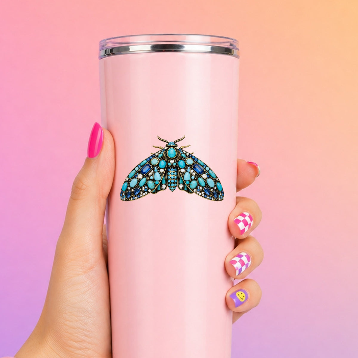 Turquoise Jeweled Moth UV DTF sticker applied to a tall pink tumbler on a pink and orange background