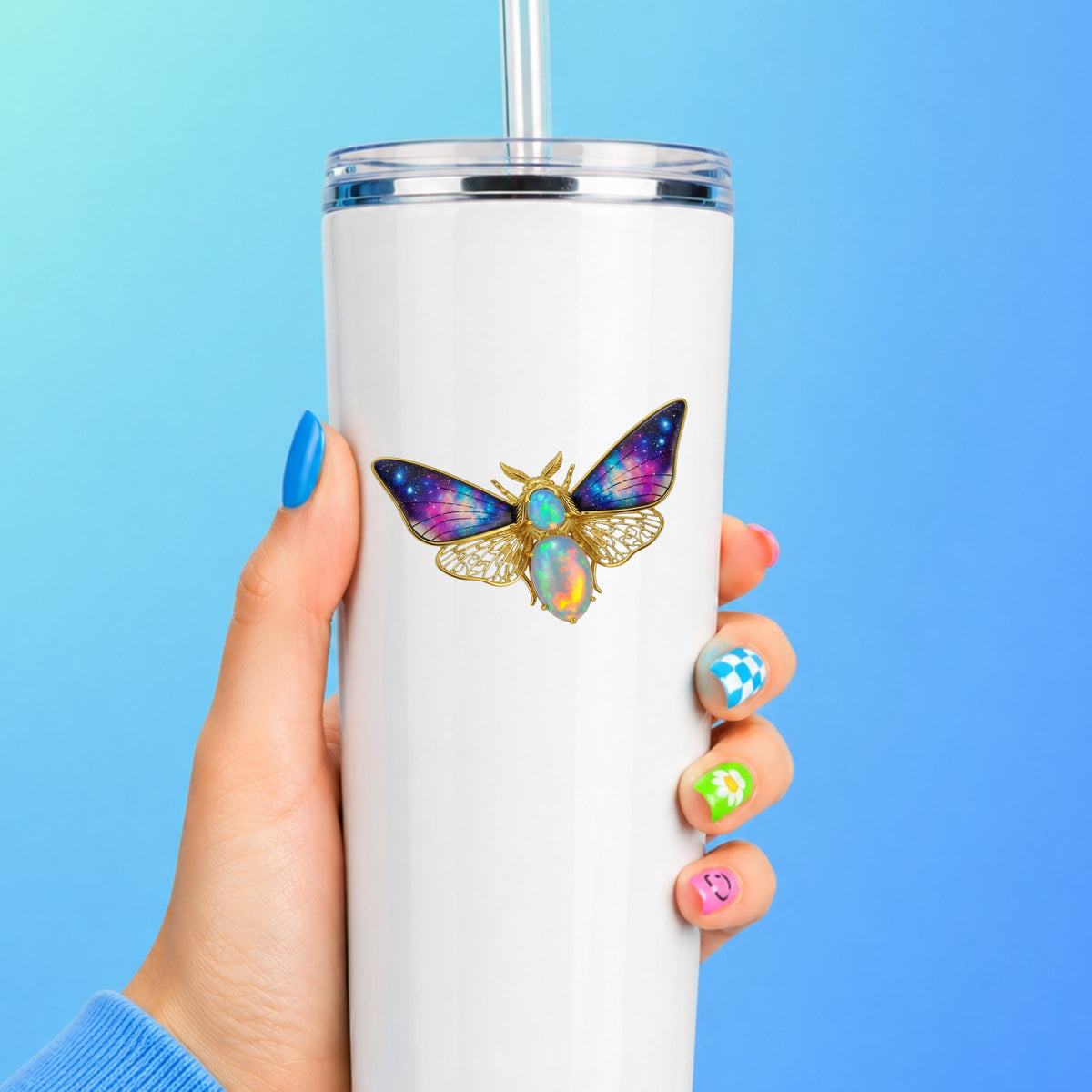 Opal Galaxy Moth UV DTF sticker applied to a white straw tumbler on a blue background