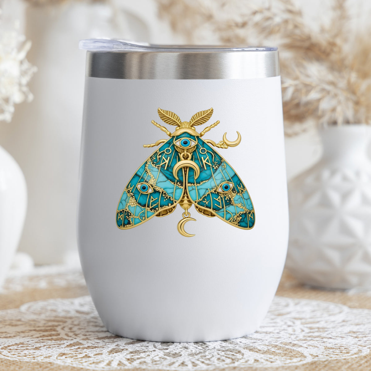 Teal Evil Eye Moth UV DTF sticker applied to a white stemless tumbler with a lid