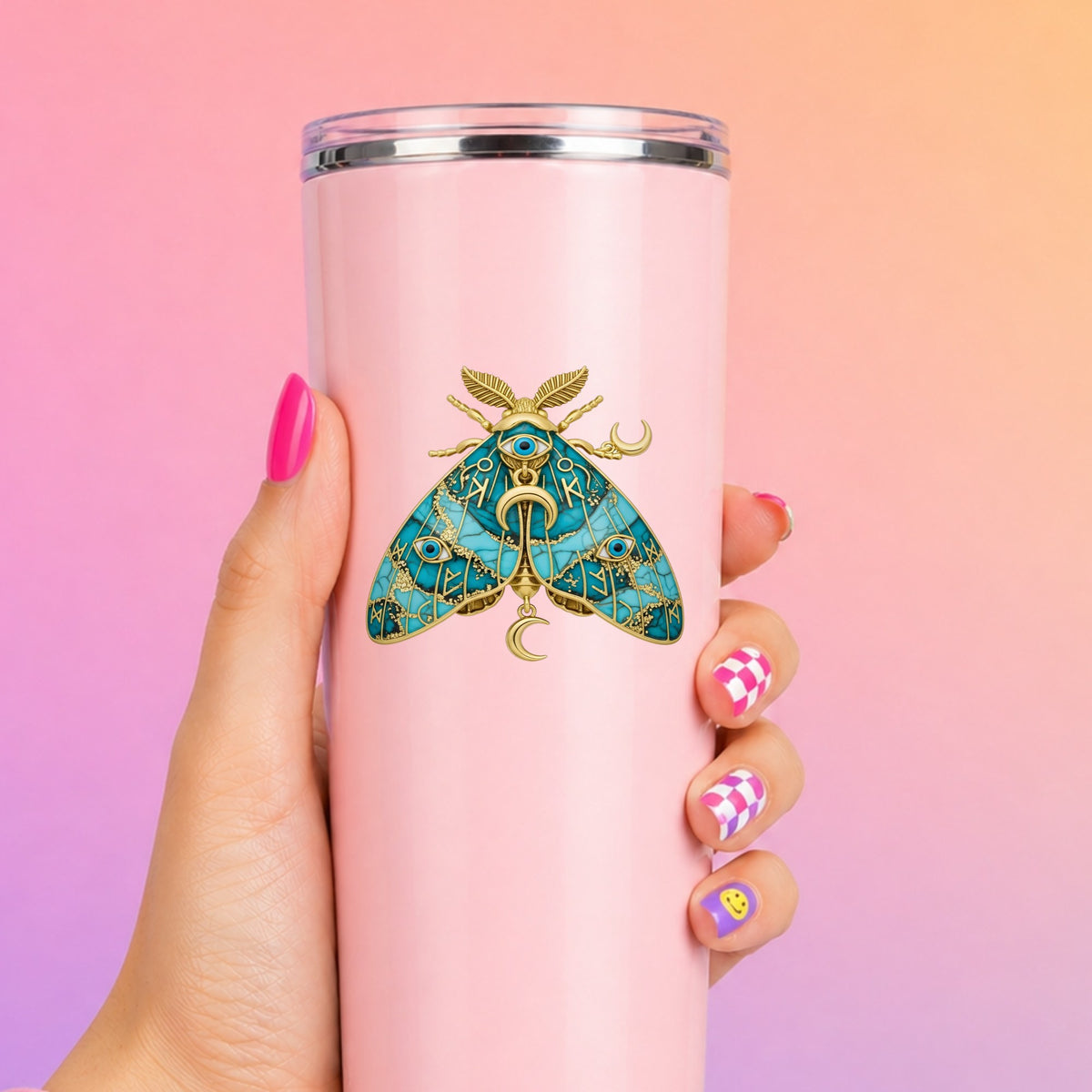 Teal Evil Eye Moth UV DTF sticker applied to a tall pink tumbler on a pink and orange background