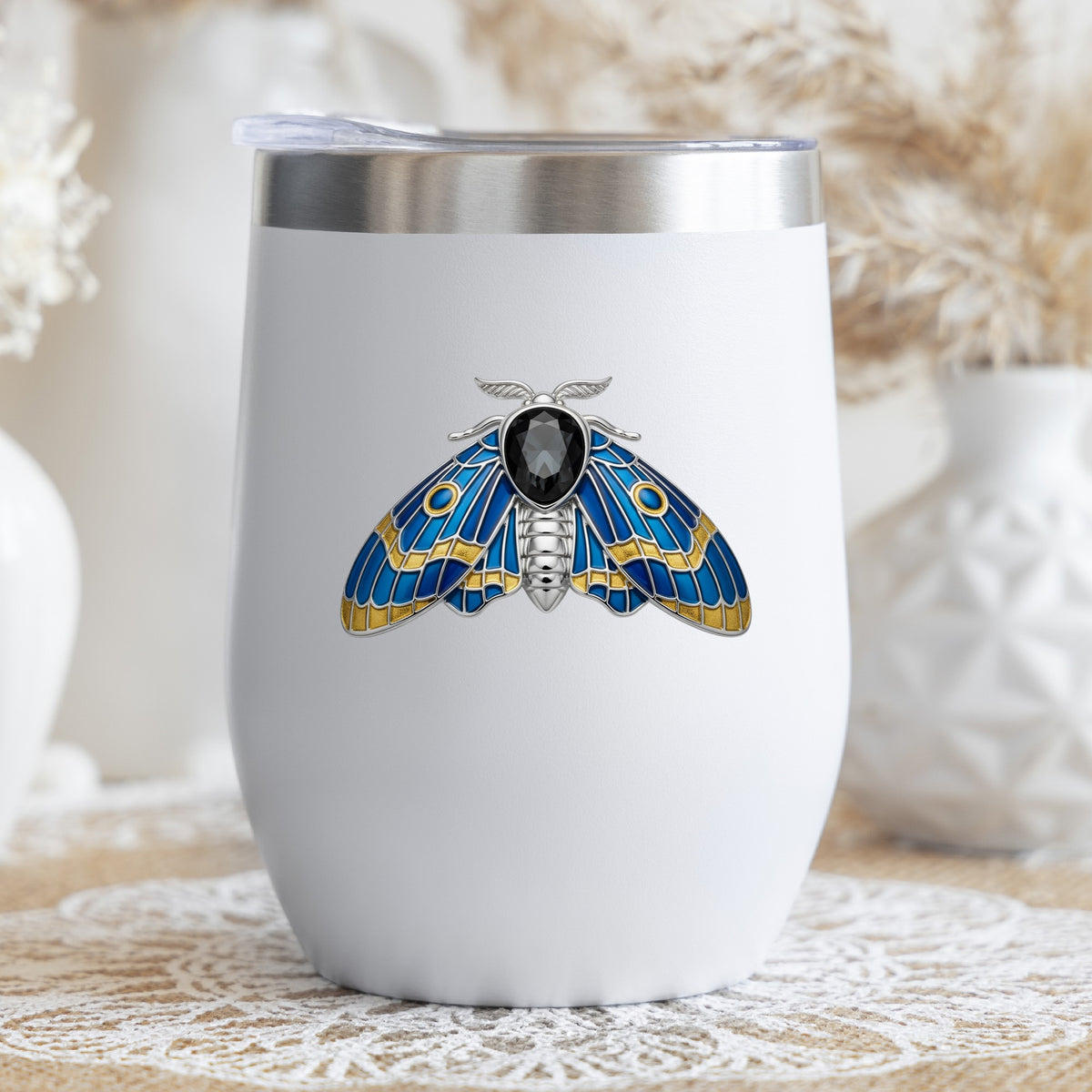 Silver Blue Enamel Moth UV DTF sticker applied to a white stemless tumbler with a lid
