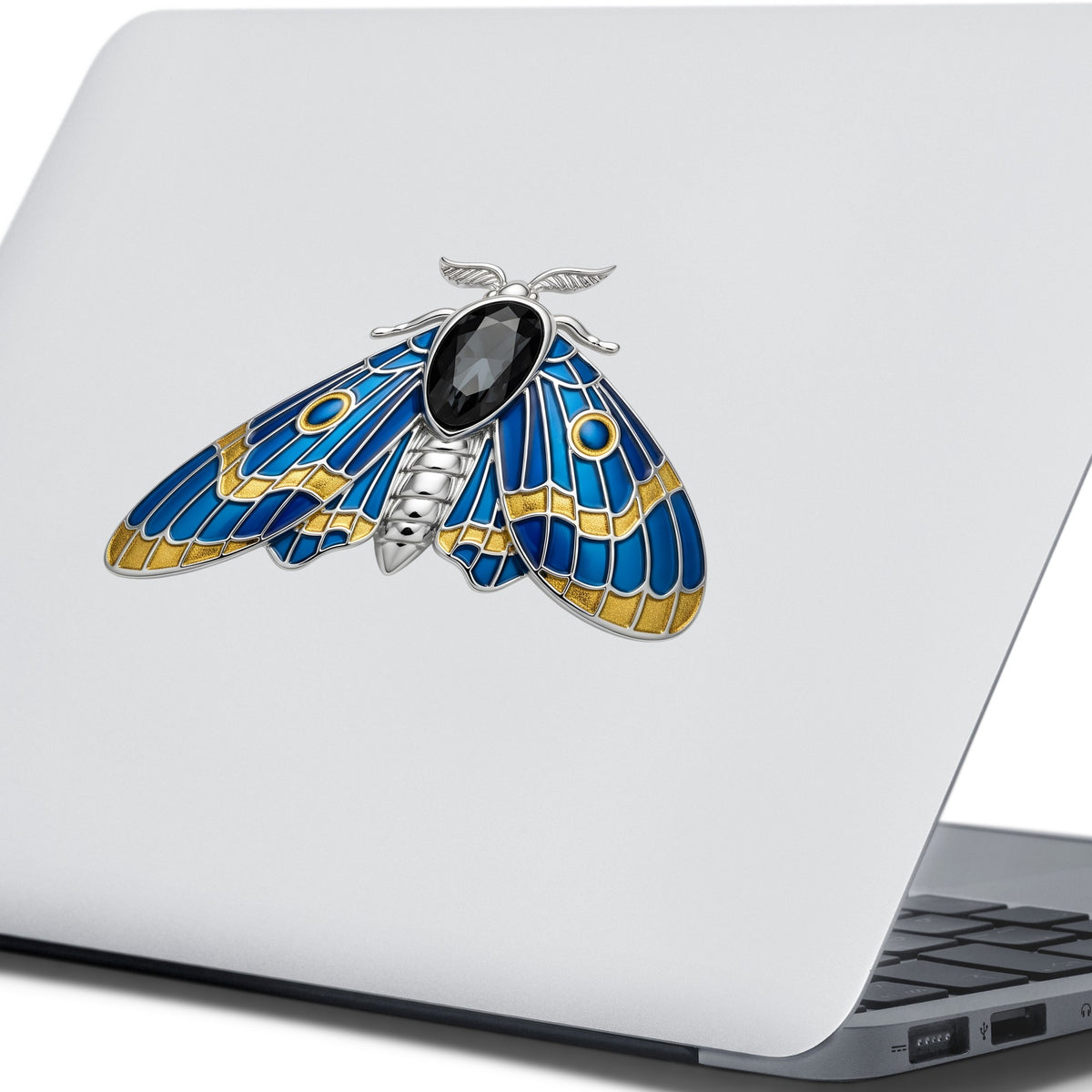 Silver Blue Enamel Moth UV DTF sticker applied to the lid of a silver laptop