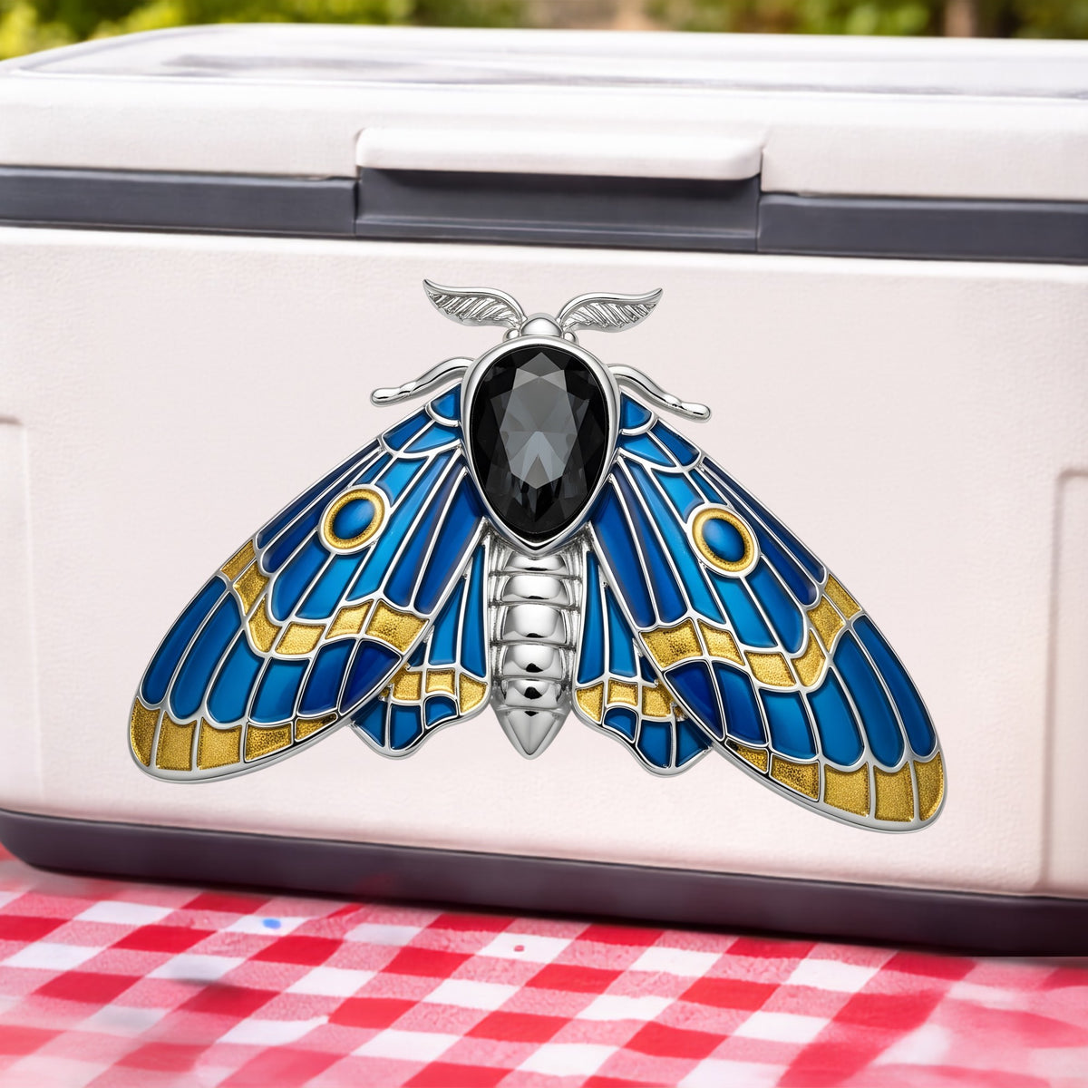 Silver Blue Enamel Moth UV DTF sticker applied to a white cooler on a red gingham cloth