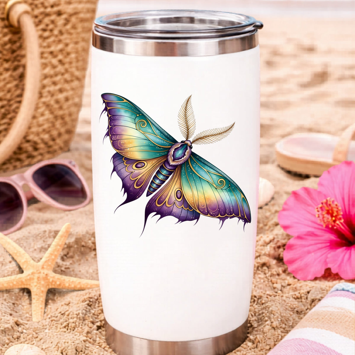 Watercolor Purple Teal Moth UV DTF sticker applied to a white travel tumbler on beach sand