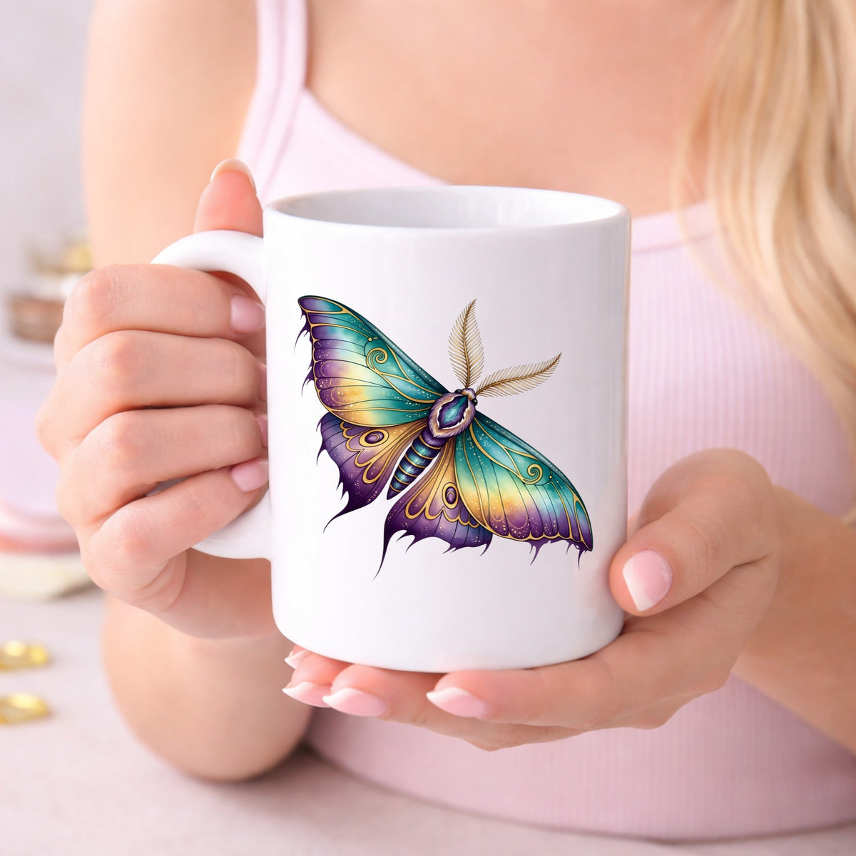 Watercolor Purple Teal Moth UV DTF sticker applied to a white coffee mug held in both hands
