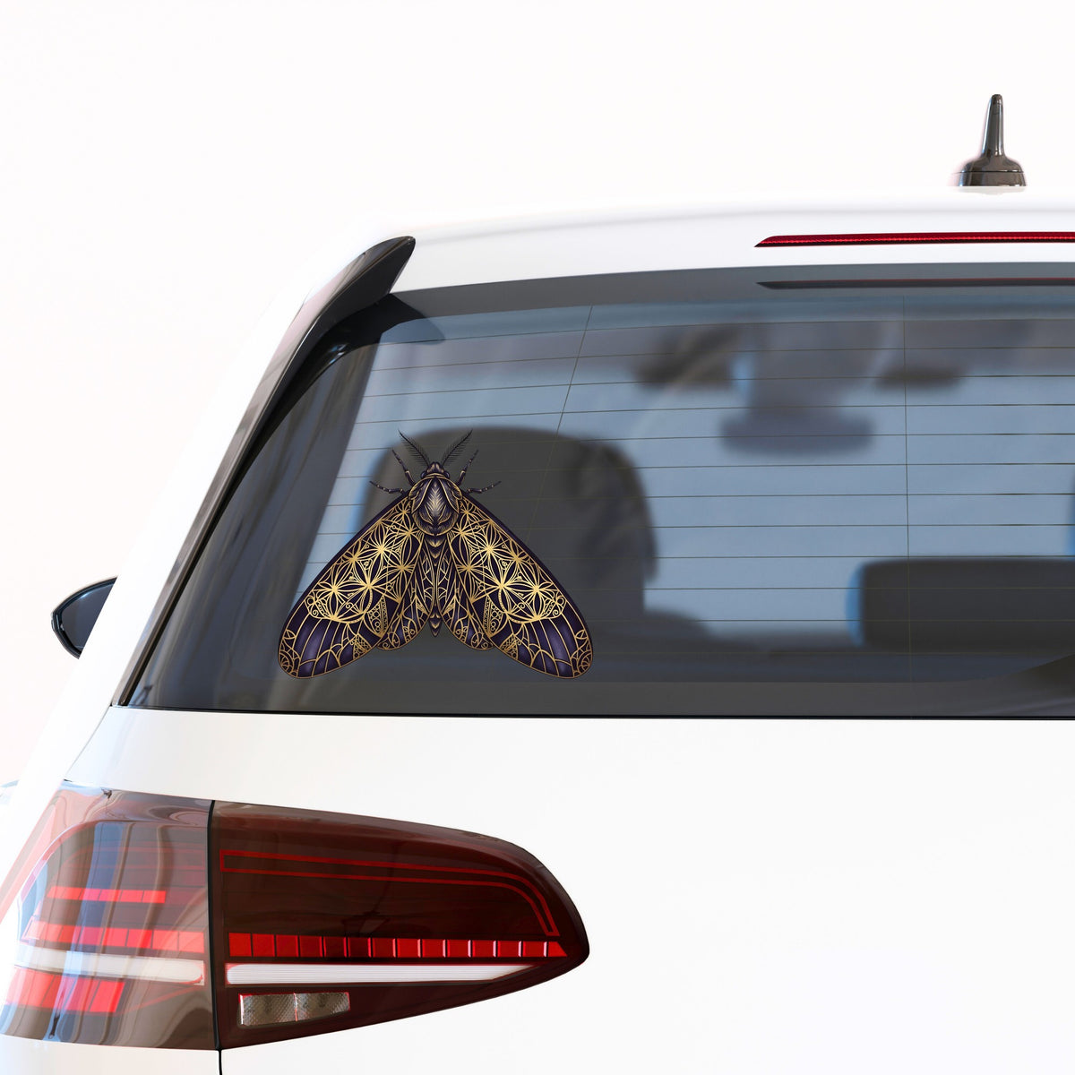 Sacred Geometry Moth UV DTF sticker applied to the rear window of a white car