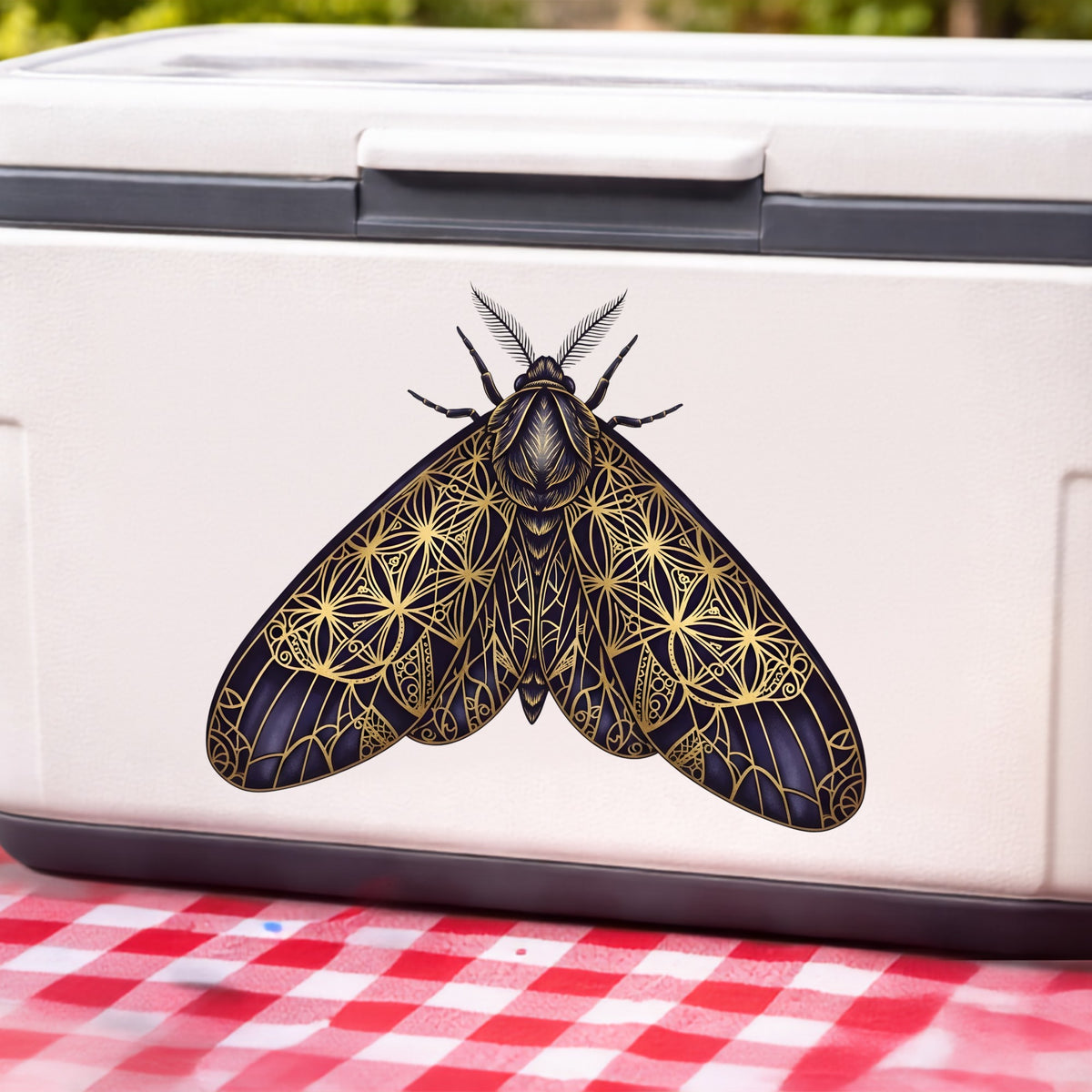 Sacred Geometry Moth UV DTF sticker applied to a white cooler on a red gingham cloth