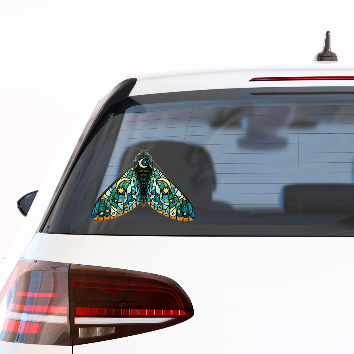 Stained Glass Moon Moth UV DTF sticker applied to the rear window of a white car