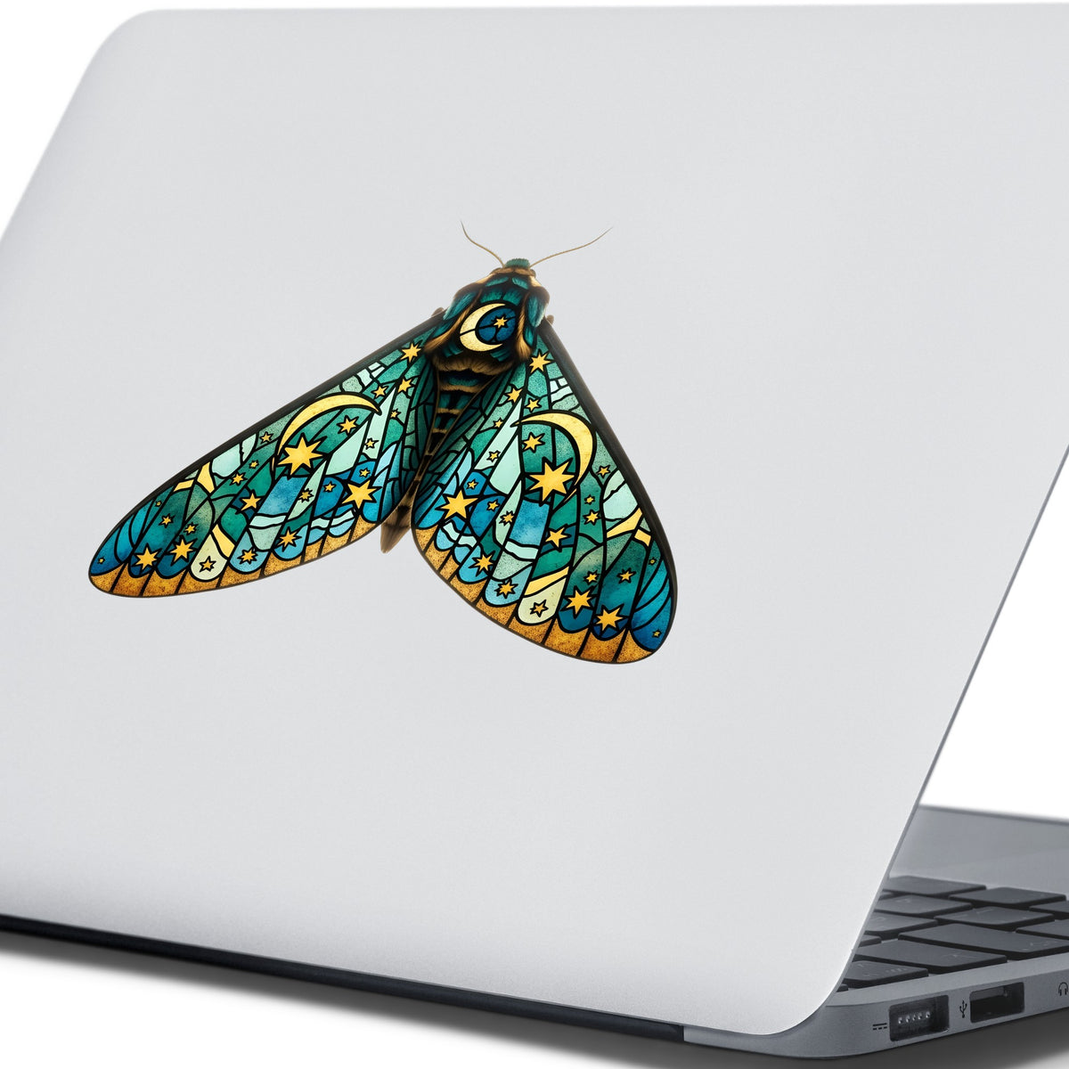Stained Glass Moon Moth UV DTF sticker applied to the lid of a silver laptop