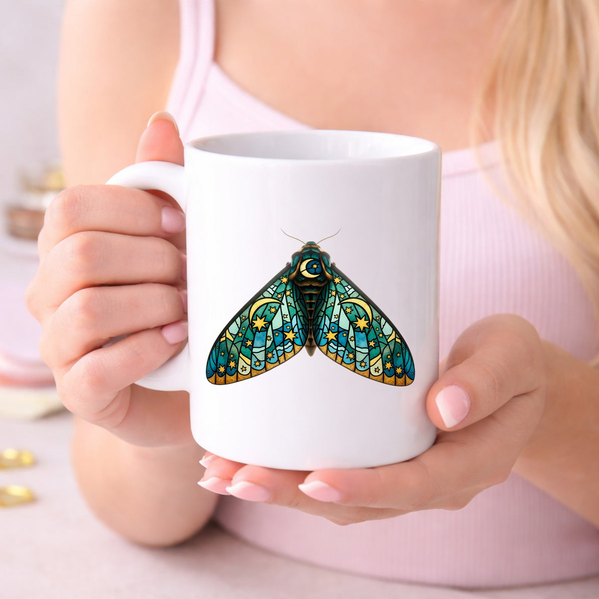 Stained Glass Moon Moth UV DTF sticker applied to a white coffee mug held in both hands