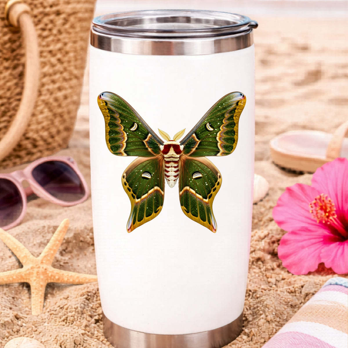 Olive Green Moth UV DTF sticker applied to a white travel tumbler on beach sand